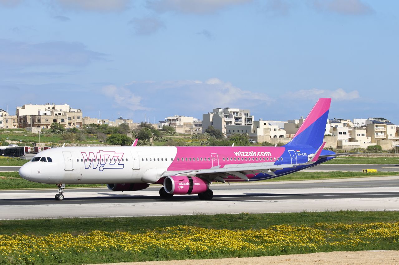 Vibrant aircraft on airport runway with clear skies.